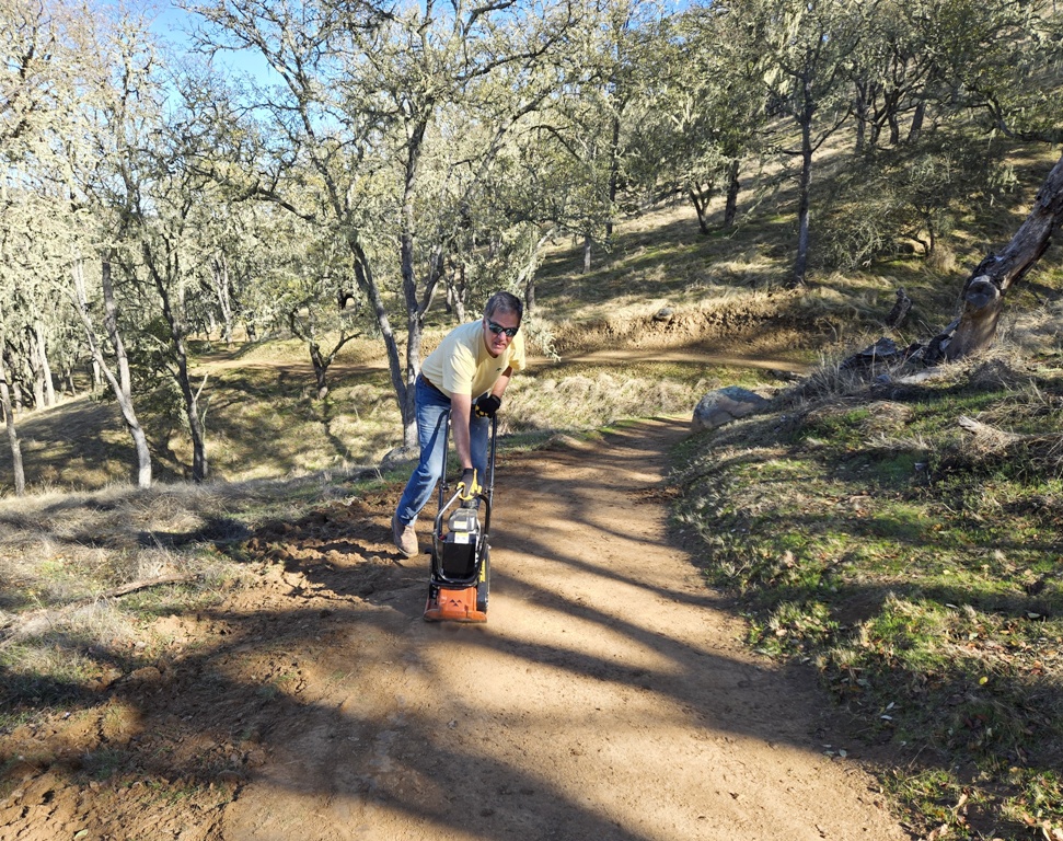 Packing the trail with the vibrating plate compactor.